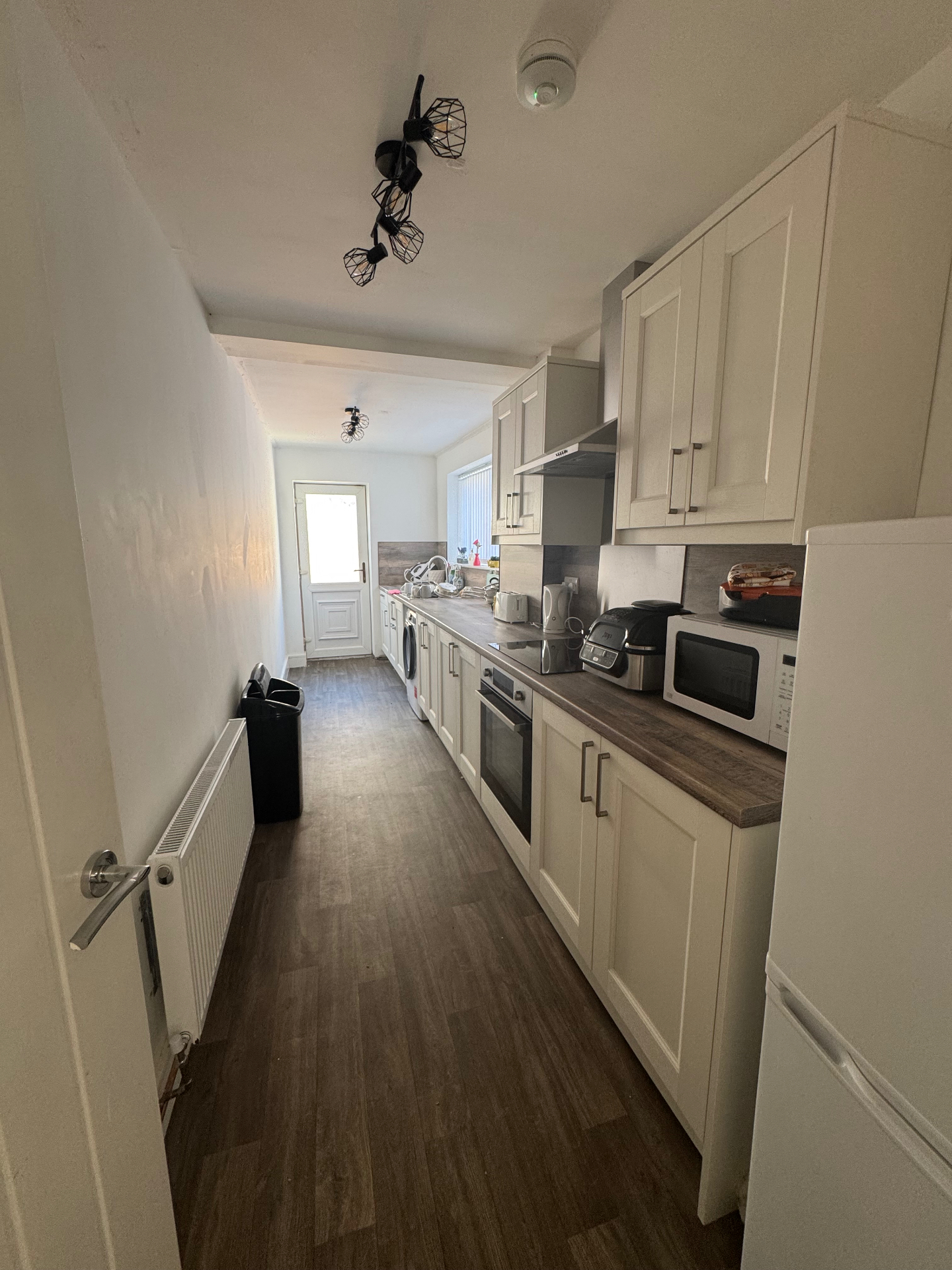 A bright, fully equipped kitchen with fitted units, oven, hob and worktop appliances